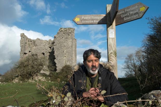 Redhill And Reigate Life: Nihal Arthanayake under a footpath sign next to Arnside Tower. Photo credit: BBC.
