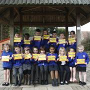 Pupils proudly show off their 100 for 100 certificates