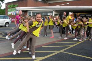 The girls of 7th Horley Brownies snaking their way around the town's Waitrose store mid-conga, with Horley mayor Richard Olliver among those joining in. Picture by Veronica Ballard. 